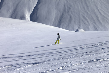 Image showing Snowboarder downhill on off piste slope with newly-fallen snow