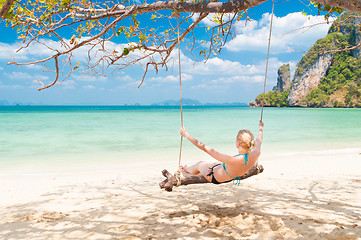 Image showing Lady swinging on the tropical beach