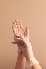 Image showing female hands adjusting vintage sheer gloves