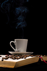 Image showing Coffee cup with coffee beans with old book