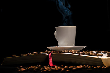 Image showing Coffee cup with coffee beans with old book