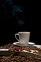 Image showing Coffee cup with coffee beans with old book