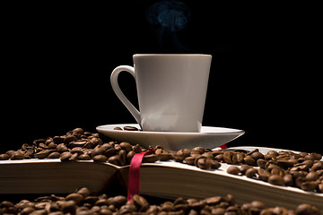 Image showing Coffee cup with coffee beans with old book