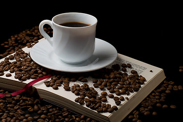 Image showing Coffee cup with coffee beans with old book