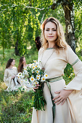 Image showing Pretty woman with bouquet of camomiles