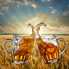 Image showing Splash of beer against wheat and sunset