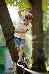 Image showing Little boy balancing on a tightrope