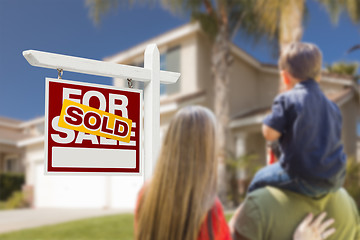 Image showing Family Facing Sold For Sale Real Estate Sign and House