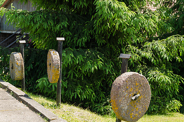 Image showing three pillars ancient millstones along hang trees 