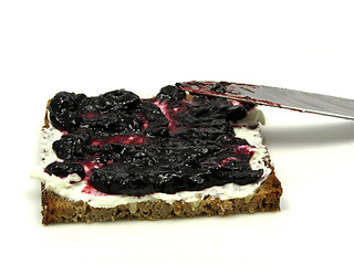 Image showing Wholemeal butterbread  with bilberry jam placed on a round plate