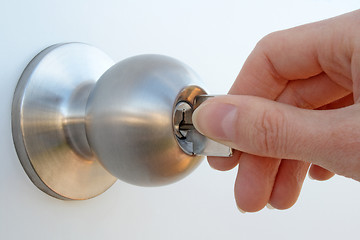 Image showing Hand unlocking the door