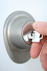 Image showing Hand unlocking the door with a key