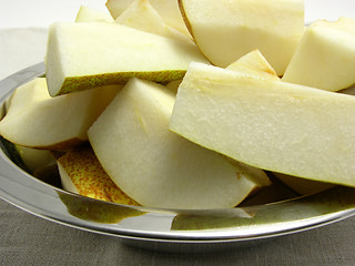 Image showing Quatered pears in a metalplate on a placemat