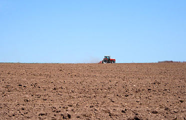 Image showing Tractor in a spring field plowing land