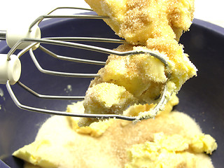 Image showing Margarine and cane sugar mixed with stirring staffs in a blue bo