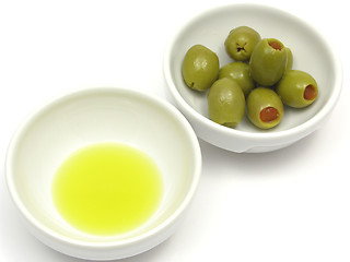 Image showing Two bowls of chinaware with olive oil and olives on white background