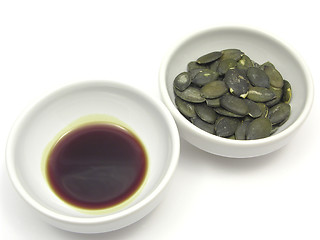 Image showing Two bowls of chinaware with pumpkin seeds and pumpkin seed oil