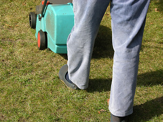 Image showing Cutout man with lawn mower doing his work