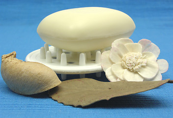 Image showing Beige soap with decoration articles on a light blue background