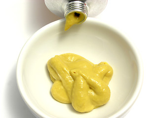 Image showing Mustard in a little bowl with mustard tube
