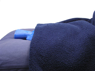 Image showing Blue hot-water bag wrapped in a blue blanket on a blue pillow