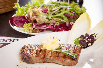 Image showing Grilled beef steak topped with butter and rosemary