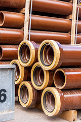 Image showing Several pipes stacked in yard