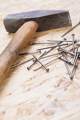 Image showing Mallet with nails and planks of new wood