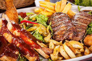 Image showing Platter of mixed meats, salad and French fries