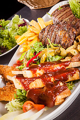 Image showing Platter of mixed meats, salad and French fries