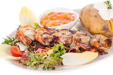 Image showing Grilled prawns with endive salad and jacket potato