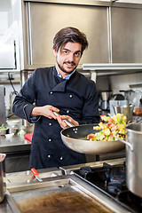 Image showing Chef cooking a vegetables stir fry over a hob