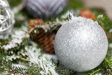 Image showing Silver Christmas bauble on a tree with snow