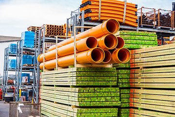 Image showing Several pipes stacked in yard