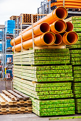 Image showing Several pipes stacked in yard