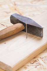 Image showing Mallet with nails and planks of new wood