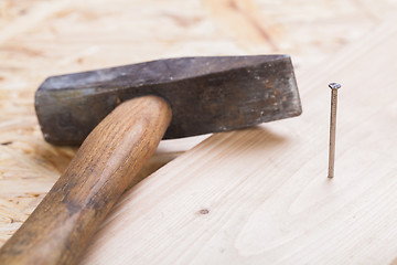 Image showing Mallet with nails and planks of new wood