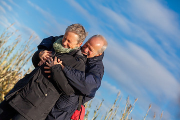 Image showing Elderly couple embracing and celebrating the sun