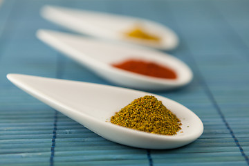 Image showing Dried ground spices in ceramic spoons