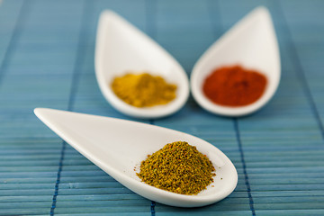 Image showing Dried ground spices in ceramic spoons