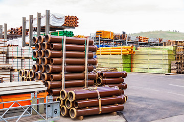 Image showing Several pipes stacked in yard