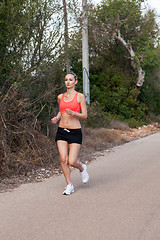 Image showing Fit young woman jogging