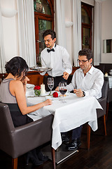 Image showing Waiter happily accommodating couple