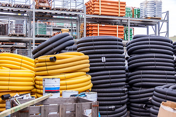 Image showing Rolls of plastic pipes in a warehouse yard