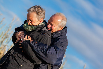 Image showing Elderly couple embracing and celebrating the sun