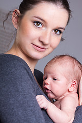 Image showing Young mother carrying infant