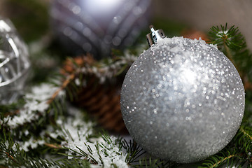 Image showing Silver Christmas bauble on a tree with snow