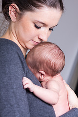 Image showing Young mother carrying infant