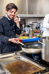 Image showing Chef taking a call on his smartphone