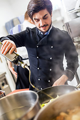 Image showing Chef cooking a vegetables stir fry over a hob